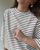 Luźny t-shirt damski w paski, widok z boku, kapsułowa stylizacja z naturalnych tkanin.